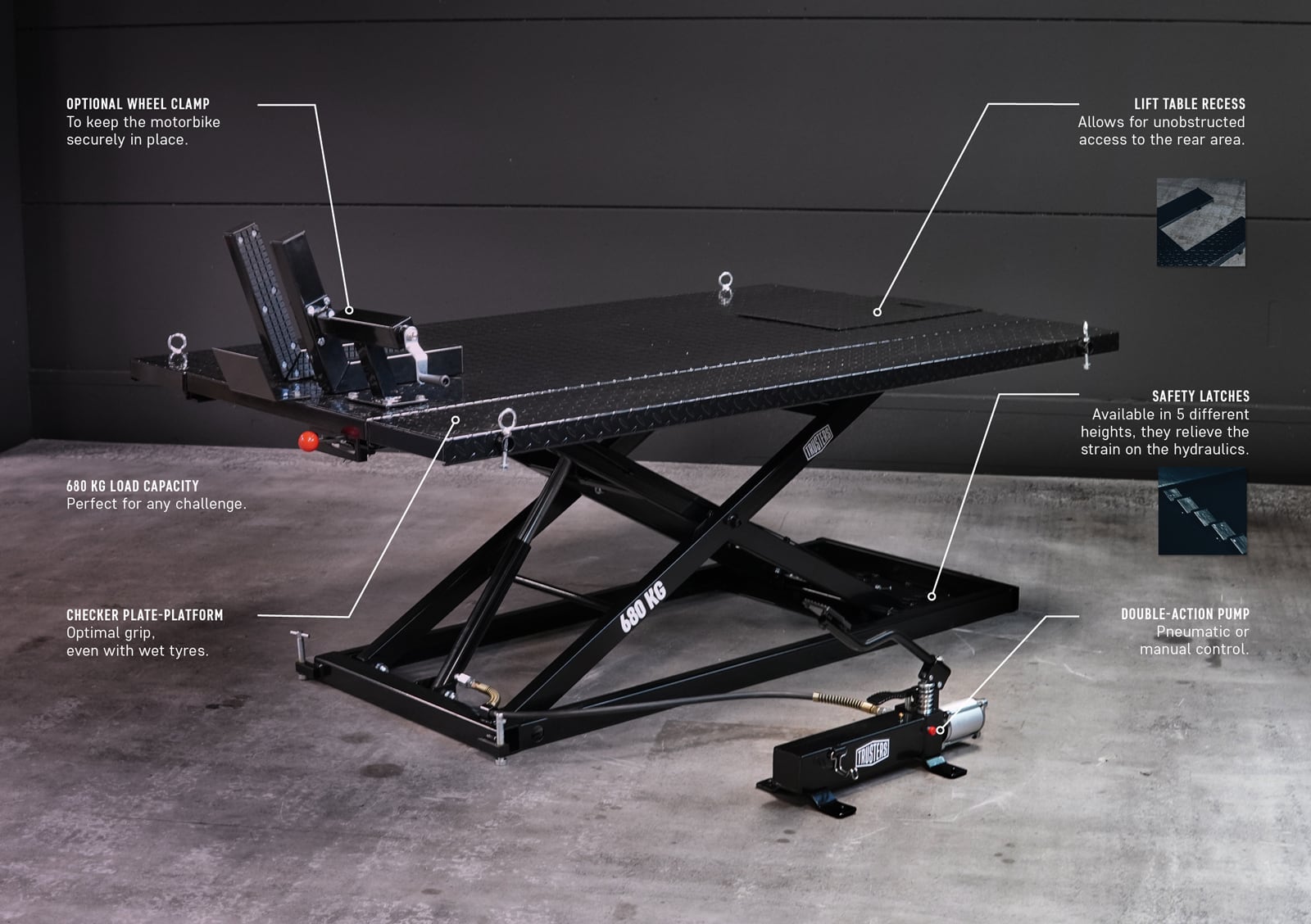 Black scissor motorcycle lift table with diamond plate platform, optional wheel clamp, safety latches, lift table recess, double-action pump and 680 kg capacity on hydraulic scissor frame in a workshop.