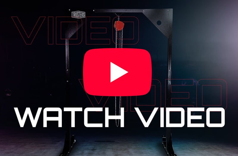 Estructura metálica con polea roja y cadena en un estudio oscuro, sobreimpresión del botón de reproducción de YouTube y texto grande WATCH VIDEO