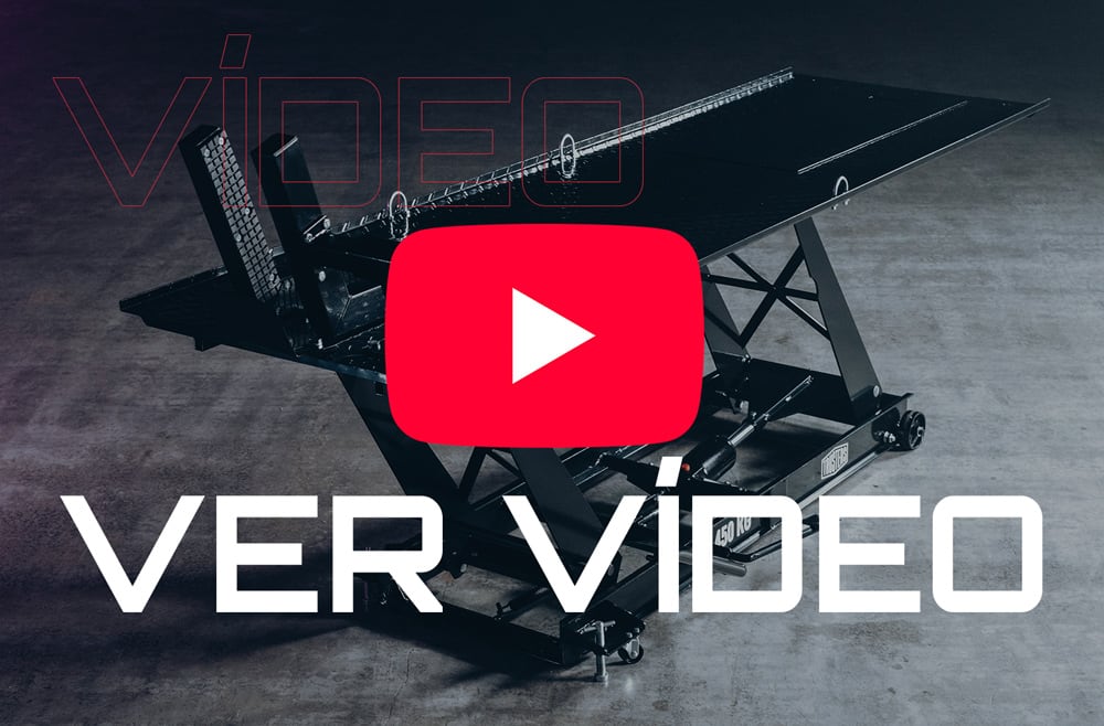 Plataforma elevadora tipo tijera negra sobre suelo de hormigón, con gran icono rojo de reproducción superpuesto en el centro y texto blanco VER VÍDEO en primer plano
