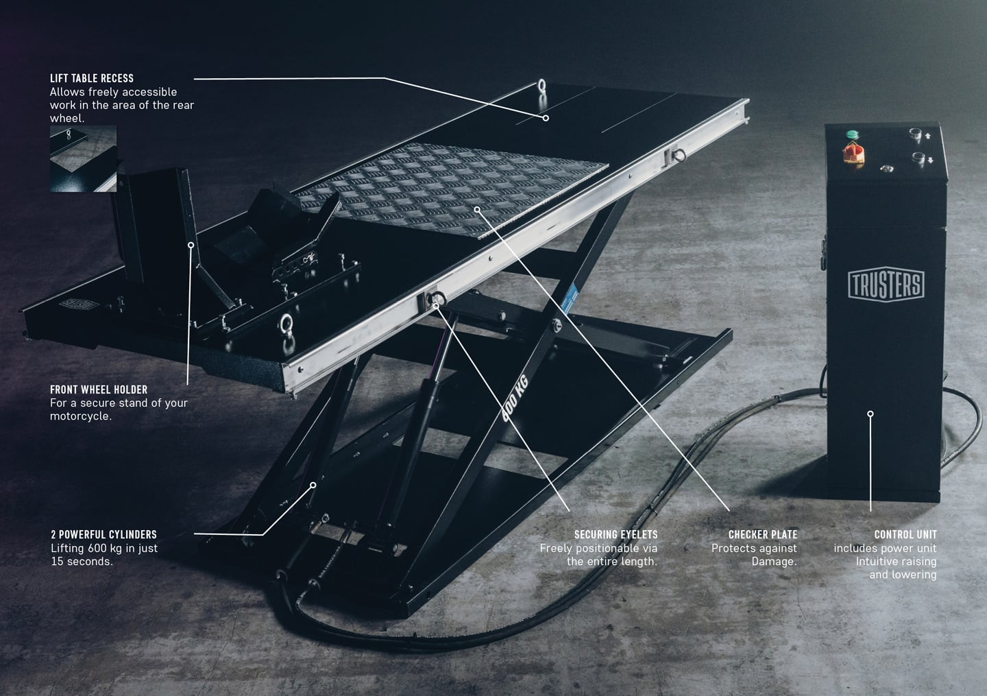 Motorcycle scissor lift table on concrete floor with black raised metal platform and checker plate, front wheel holder, securing eyelets, dual hydraulic cylinders, coiled hose and separate TRUSTERS control unit