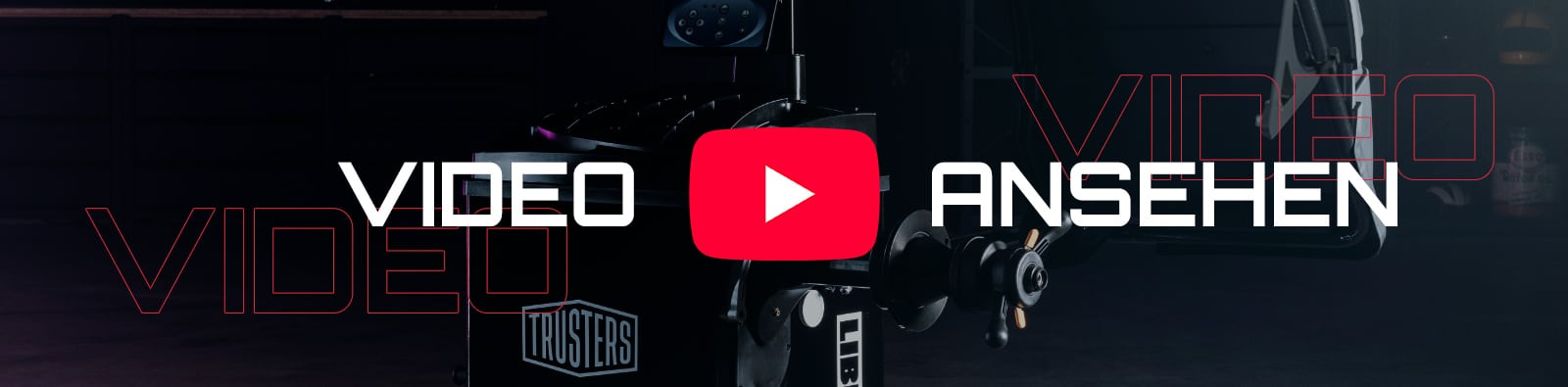 Dunkle Szene mit großem roten YouTube-Play-Button in der Bildmitte, weißer Schriftzug VIDEO ANSEHEN und teilweise sichtbare Filmkamera im Hintergrund