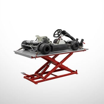 Schwarzes Go-Kart mit Motor und Reifen auf grauer Plattform eines roten Scheren-Hubtisches vor weißem Hintergrund