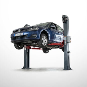 Blauer Volkswagen-Pkw auf einer zweisäuligen Autohebebühne, Unterboden und Räder sichtbar, helle Werkstattumgebung
