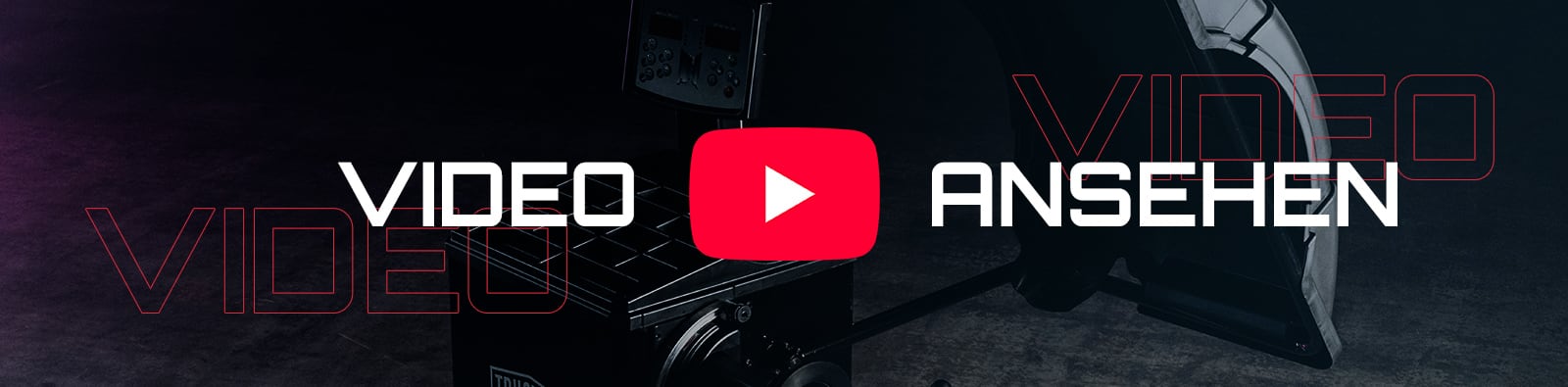 Rotes YouTube-Play-Symbol mit weißem Dreieck zwischen den weißen Worten VIDEO und ANSEHEN vor dunklem Studiohintergrund mit Kamera- und Licht-Equipment