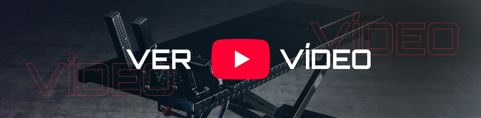 Mesa elevadora negra sobre suelo gris con icono rojo de reproducción de YouTube centrado y el texto en mayúsculas VER VÍDEO superpuesto, con contornos y líneas rojas de la palabra VIDEO en el fondo