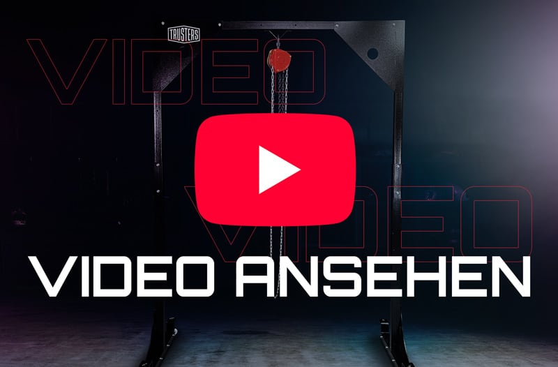 Rotes YouTube-Play-Symbol über einer schwarzen Metall-Konstruktion mit Ketten und rotem Flaschenzug; großer weißer Text VIDEO ANSEHEN vor dunklem, leicht beleuchtetem Hintergrund