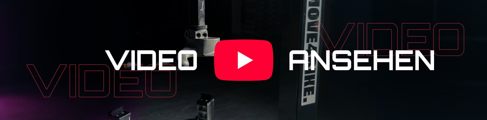 Rotes YouTube-Play-Icon zentriert zwischen großen weißen Worten VIDEO (links) und ANSEHEN (rechts) vor dunklem Studioboden mit Metallstativteilen und roten Kontur-VIDEO-Schriftzügen