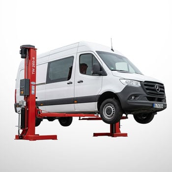 Weißer Mercedes-Sprinter Transporter auf roter Zwei-Säulen-Hebebühne angehoben, seitliche Ansicht