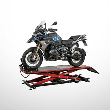 Adventure-Motorrad in Schwarz und Blau auf angehobener roter Scherenhebebühne, Seitenansicht vor weißem Hintergrund