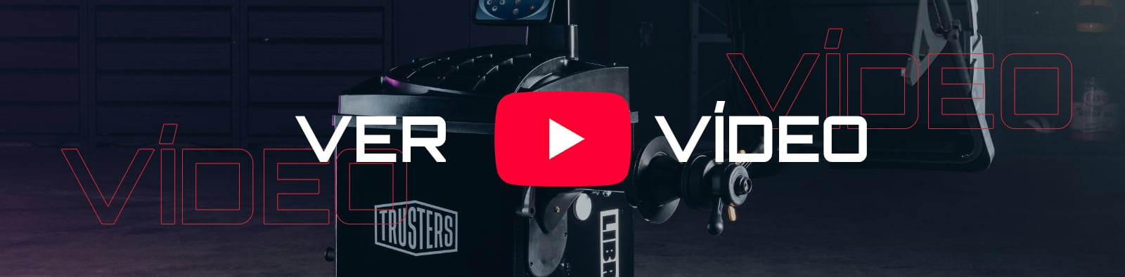 Equipo industrial oscuro con logo Trusters, primer plano de una máquina con manivela; sobreimpreso un gran botón rojo de reproducción de YouTube y el texto blanco VER VÍDEO en el centro del encuadre
