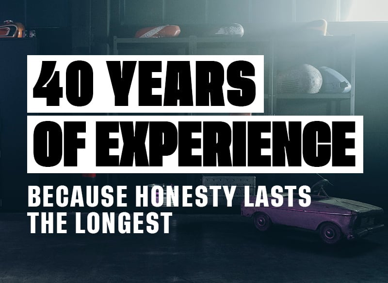 Large white bold text 40 YEARS OF EXPERIENCE with smaller tagline Because honesty lasts the longest over a dim garage scene featuring vintage toy cars on shelves and the floor