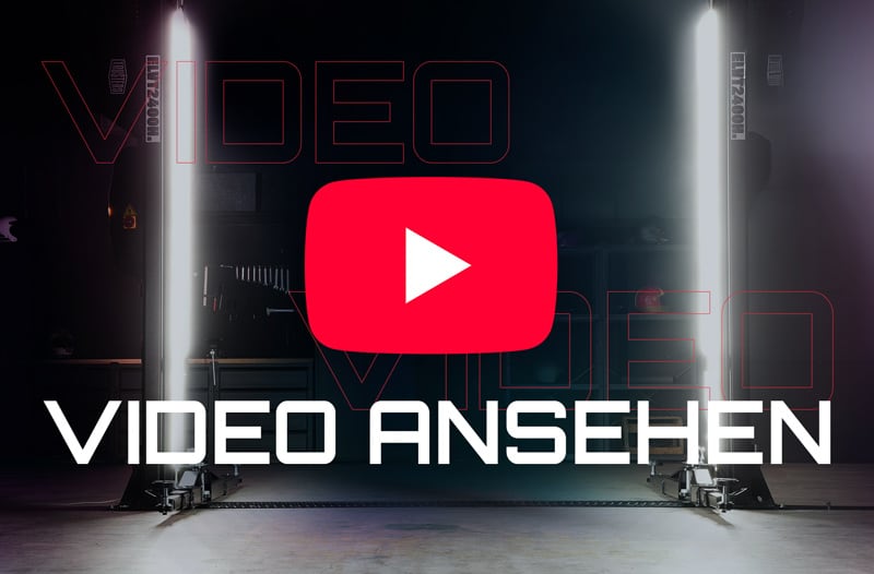 Rotes YouTube-Play-Logo zentral über großem weißen Schriftzug VIDEO ANSEHEN, flankiert von zwei vertikalen Studiolichtern links und rechts vor dunklem Aufnahme-Studio-Hintergrund
