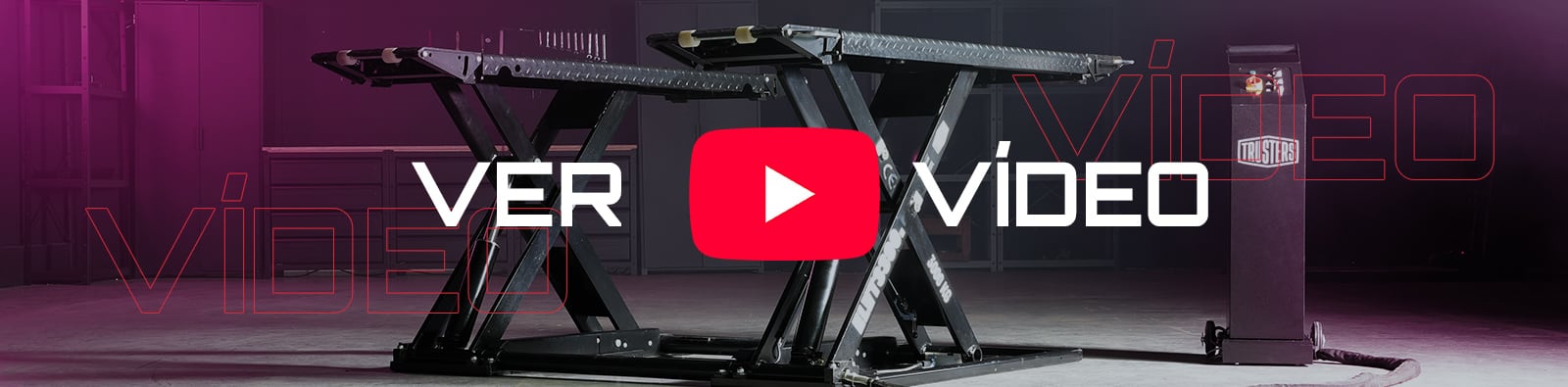 Plataforma elevadora tipo tijera negra en un taller vacío, con un gran botón rojo de reproducción de YouTube y el texto superpuesto VER VÍDEO